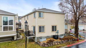 View of side of property featuring a lawn and stucco siding