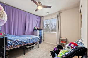 Bedroom featuring a ceiling fan, baseboards, visible vents, and carpet flooring