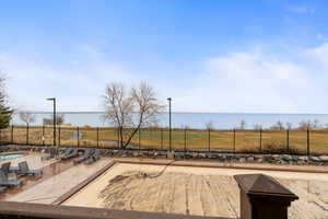 View of pool with a fenced in pool, a patio area, a water view, and a fenced backyard