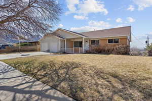 Single story home with a garage, brick siding, concrete driveway, covered