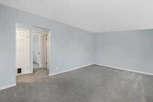 Additional living space with carpet floors, baseboards, and visible vents