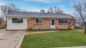 Ranch-style home featuring a shingled roof, brick siding, and a front lawn