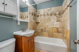 Bathroom with shower / washtub combination, vanity, and toilet