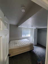 Unfurnished bedroom featuring a textured ceiling and carpet