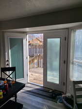 Entryway with a textured ceiling and wood finished floors