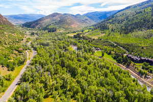 Birds eye view of property with a mountain view and a view of trees