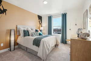 Bedroom with light colored carpet and baseboards