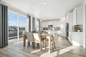 Dining space with recessed lighting and light wood-style floors