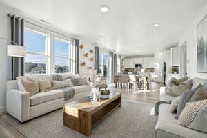 Living room featuring visible vents, recessed lighting, and light wood-style floors