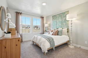 Bedroom featuring light carpet and baseboards