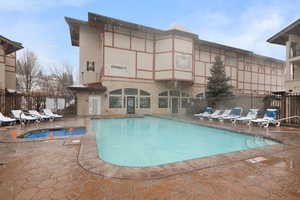 Community pool with a patio and fence