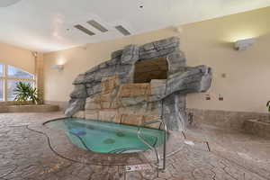 View of swimming pool featuring a patio area and an indoor hot tub