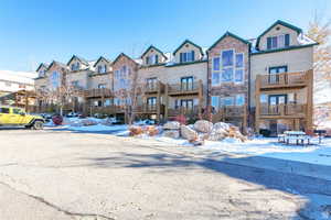 Townhome / multi-family property with stone siding and a residential view