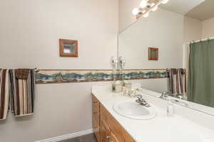 Full bath featuring baseboards and vanity