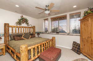 Bedroom featuring light carpet, a textured ceiling, and visible vents