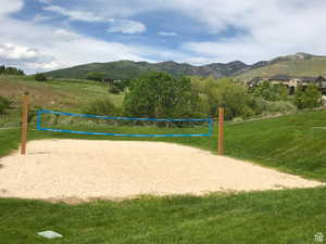 View of property's community featuring a mountain view, volleyball court, and a lawn