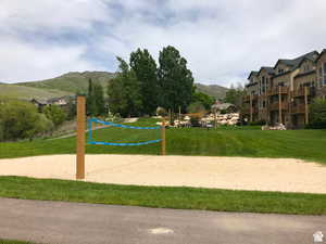 View of community featuring a yard, a mountain view, and volleyball court