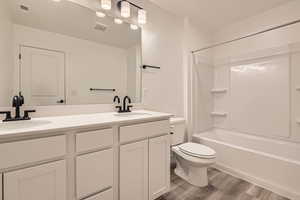 Full bathroom featuring a sink, visible vents, toilet, and wood finished floors