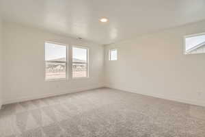 Spare room featuring light carpet, recessed lighting, visible vents, and baseboards