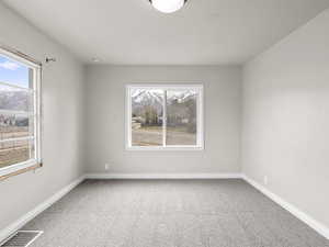 Spare room with carpet floors, visible vents, and baseboards