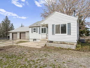 Back of house featuring an outbuilding, roof with shingles, fence, and central air condition unit