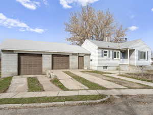 View of front of home with a garage, driveway, a chimney, and roof with shingles