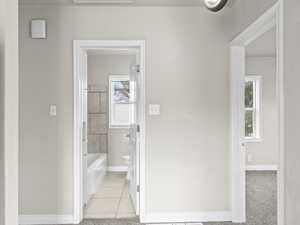 Full bathroom with baseboards, toilet, and tile patterned floors