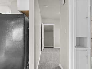 Hallway with carpet and baseboards