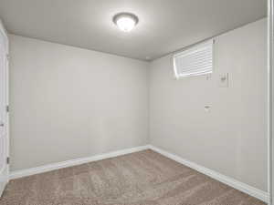 Carpeted spare room with baseboards