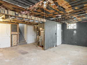 Basement featuring water heater and stairway