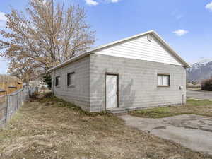 Rear view of property featuring concrete block siding, fence, and a mountain view