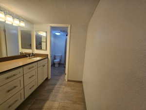 Bathroom featuring toilet, baseboards, and vanity