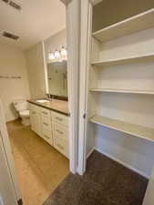 Full bathroom with tile patterned floors, visible vents, toilet, and vanity