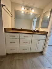 Full bathroom with wood finished floors and vanity