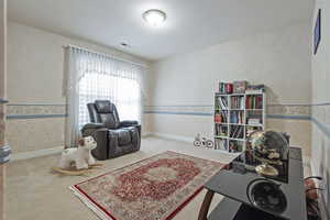 Sitting room featuring carpet flooring, visible vents, baseboards, and wallpapered walls