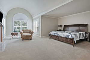 Bedroom featuring light carpet, ornamental molding, and baseboards