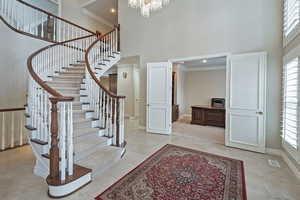 Entrance foyer featuring a wealth of natural light, baseboards, visible vents, and a high ceiling