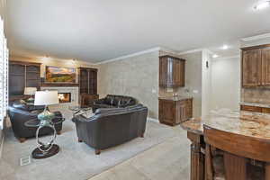 Living area featuring recessed lighting, visible vents, ornamental molding, and a tile fireplace