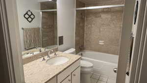 Bathroom with toilet, shower / bathtub combination, vanity, and tile floors