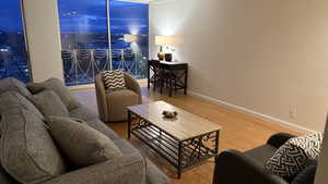 Living room featuring floor to ceiling windows, baseboards, and wood finished floors