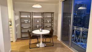 Dining room with baseboards, ornamental molding, and light wood-style floors