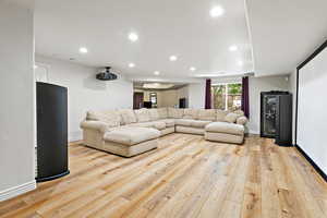 Living room with wood-type flooring, visible vents, baseboards, and recessed lighting