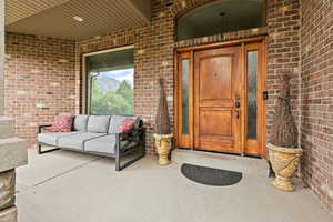 Doorway to property with brick siding and outdoor lounge area