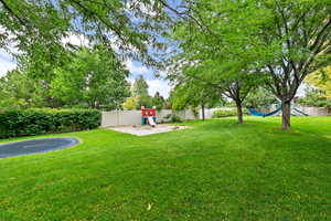 View of yard with a playground and a fenced backyard