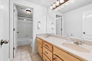 Bathroom featuring toilet, tile patterned flooring, visible vents, and a sink