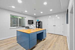 Office with light wood-style flooring, recessed lighting, visible vents, and baseboards