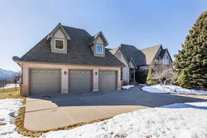 View of front of home featuring a garage, roof with shingles, fence, and brick siding