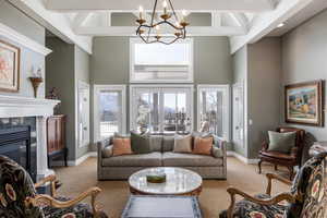 Living room featuring a high ceiling, baseboards, carpet flooring, and a tiled fireplace