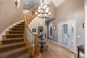 Foyer with high vaulted ceiling, visible vents, light wood-style flooring, and baseboards