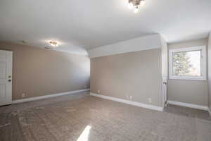 Carpeted empty room featuring visible vents and baseboards